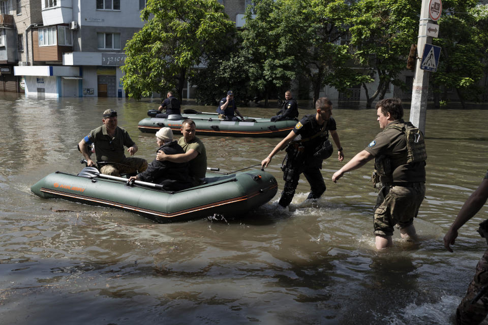 A woman is evacuated from a flooded neighborhood in Kherson, Ukraine, Wednesday, June 7, 2023 after the Kakhovka dam was blown up. Residents of southern Ukraine braced for a second day of swelling floodwaters on Wednesday as authorities warned that a Dnieper River dam breach would continue to unleash pent-up waters from a giant reservoir. (AP Photo/Roman Hrytsyna)