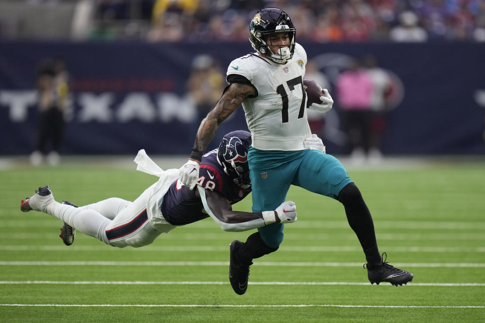 Jacksonville Jaguars tight end Evan Engram (17) is hit from behind by Houston Texans linebacker Christian Harris (48) after making a catch during the second half of an NFL football game in Houston, Sunday, Jan. 1, 2023. (AP Photo/Eric Christian Smith)