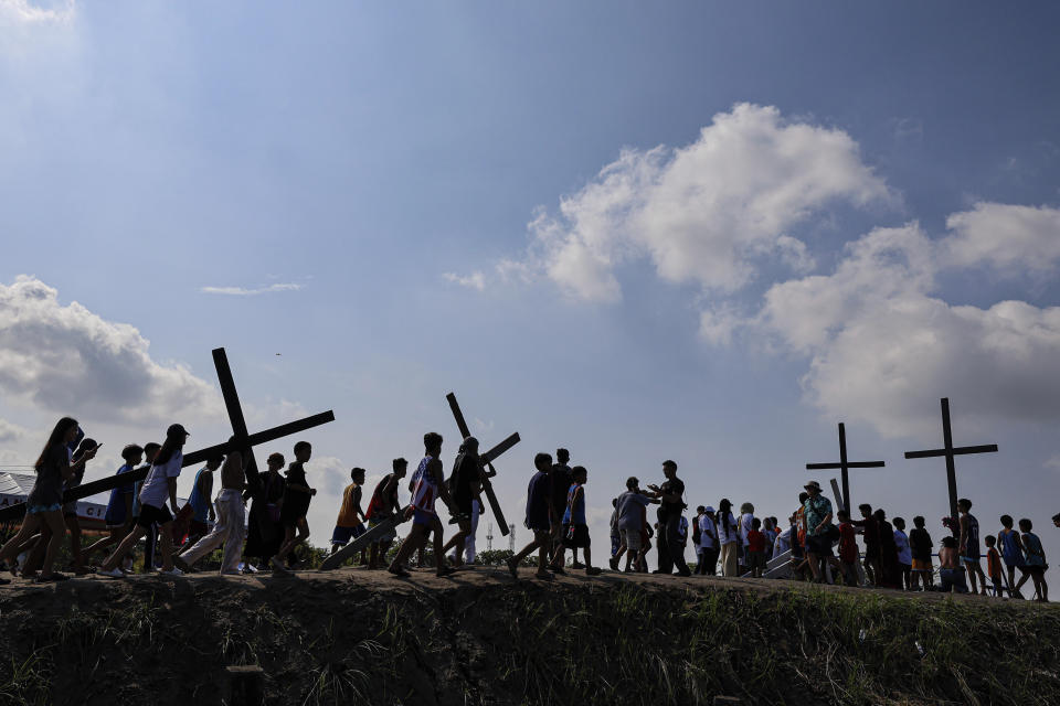 Filipino penitents carry their crosses atop the crucifixion mound during Good Friday rituals in San Pedro Cutud, north of Manila, Philippines, Friday, March 29, 2024. (AP Photo/Gerard V. Carreon)