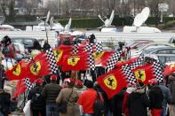 Ferrari fans from France, Italy and Germany attend a silent 45th birthday tribute to seven-times former Formula One world champion Michael Schumacher in front of the CHU hospital emergency unit in Grenoble, French Alps, where Michael Schumacher is hospitalized January 3, 2014. REUTERS/Charles Platiau