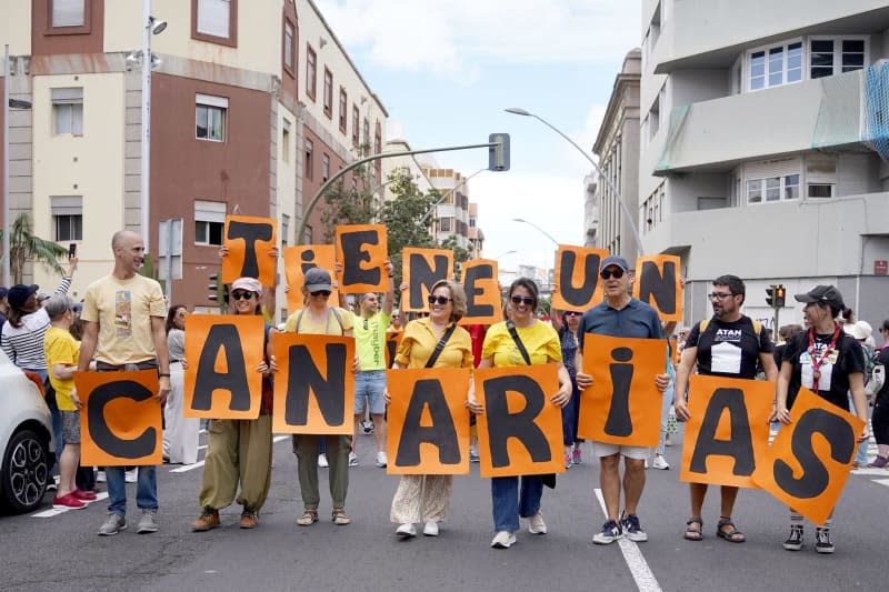 People hold placards during a demonstration against the tourism model under the slogan 'Canarias has a limit'. -/EUROPA PRESS/dpa