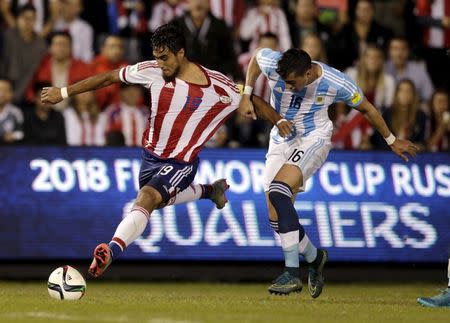 Paraguay's Dario Lezcano (L) and Argentina's Ramiro Funes Mori battle for the ball during their 2018 World Cup qualifying soccer match at the Defensores del Chaco stadium in Asuncion, Paraguay, October 13, 2015. REUTERS/Jorge Adorno