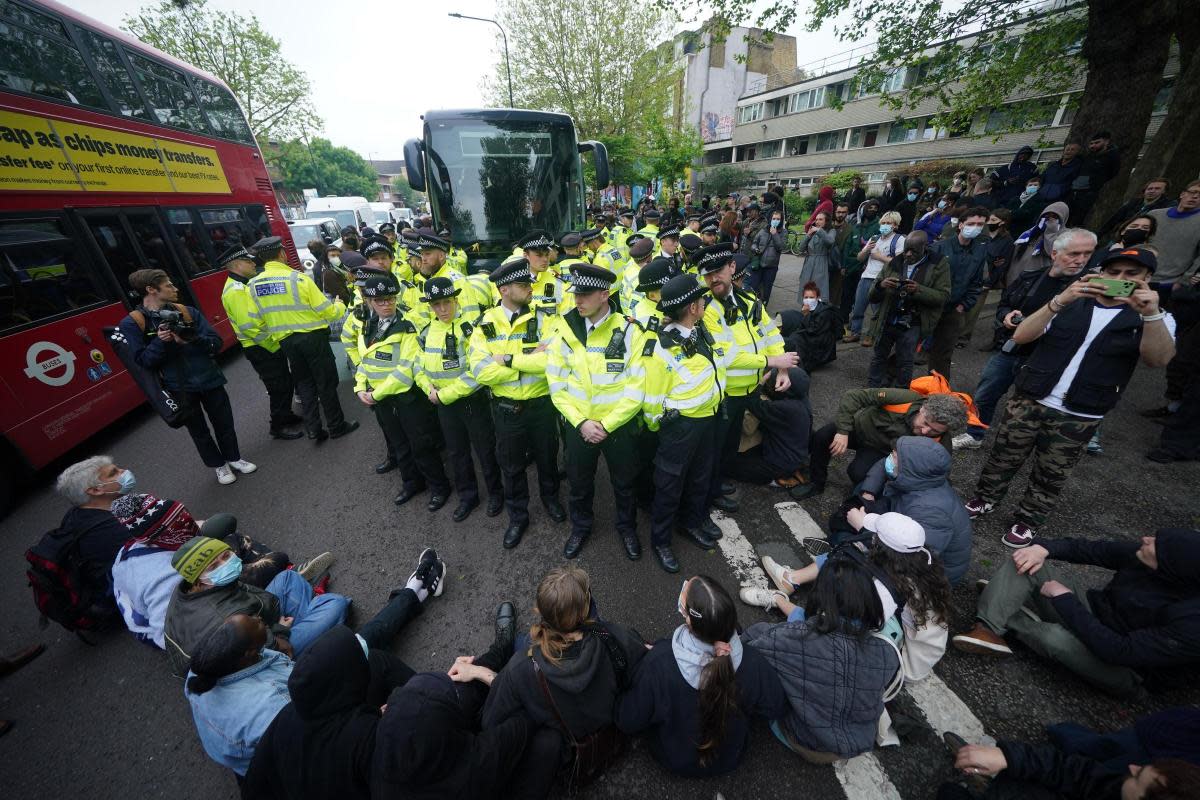 Police with protesters who formed a blockade around a coach which is parked near the Best Western hotel in Peckham, south London <i>(Image: PA)</i>