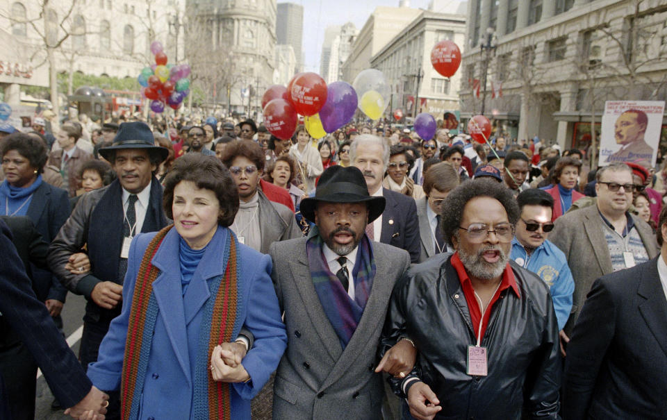 FILE - Dianne Feinstein, left, California assembly speaker Willie Brown, center, and Rev. Cecil Williams of the Glide Memorial Church of San Francisco, hold hands during a Dr. Martin Luther King Jr. Day march in downtown San Francisco, Jan. 20, 1986. Williams, who with his late wife turned Glide Church in San Francisco into a world-renowned haven for poor, homeless, and marginalized people, died Monday, April 22, 2024, at his home in San Francisco. He was 94. (AP Photo/Paul Sakuma,File)