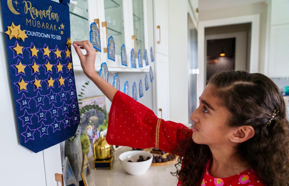 Sareena Kheiri, 10, places star on her family's Ramadan countdown calendar Friday, April 15, 2022, inside her Carmel, Indiana, home. 