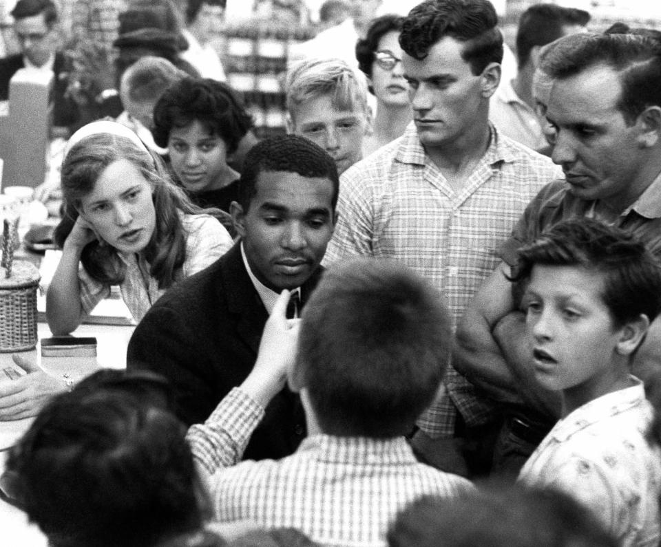 Dion Diamond, a student at Howard University in Washington, D.C., is surrounded by white youths during a sit-in demonstration at an Arlington, Virginia, drug store, June 9, 1960. Blacks are seeking service at lunch counters where only white persons now are served. The woman at left is civil rights activist Joan Trumpauer.