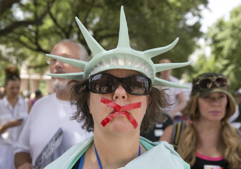 <p>Deborah Campbell, dressed as the Statue of Liberty with red tape over her mouth, attends the Families Belong Together rally at the Capitol in Austin, Texas, on Saturday, June 30, 2018. (Photo: Jay Janner/Austin American-Statesman via AP) </p>