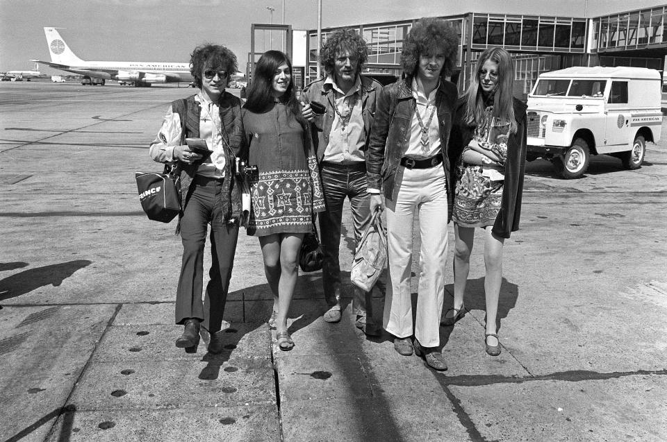 FILE - In this Aug. 20, 1967 file photo, members of the rock group Cream, from left, Jack Bruce, unidentified woman, drummer Ginger Baker, and  Eric Clapton.  depart from Heathrow Airport in London.  Bruce, best known as the bassist from Cream, has died. He was 71. A statement released by his family announced the death Saturday, Oct. 25, 2014.  Publicist Claire Singers said Bruce died at his home in Suffolk, England. (AP Photo/Peter Kemp)