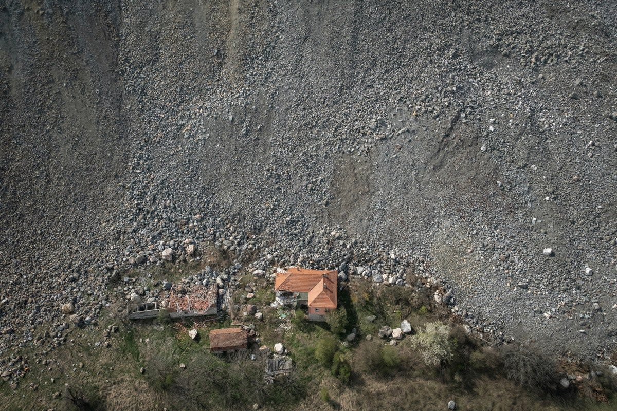 A destroyed house is seen near an open-pit copper mine (Reuters)