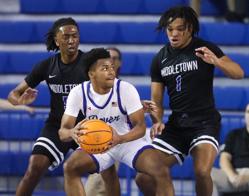 Dover's Dorell Little moves to the basket against Middletown's Eric Mathenge (left) and Aviyon Matthews in the first half of a DIAA state tournament semifinal at the Bob Carpenter Center, Thursday, March 7, 2024.