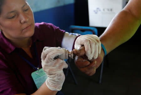 A Nicaraguan voter (R) gets his thumb marked with indelible ink by an electoral official after casting ballot at a polling station during the Nicaragua's presidential elections in Managua, November 6, 2016. REUTERS/Oswaldo Rivas