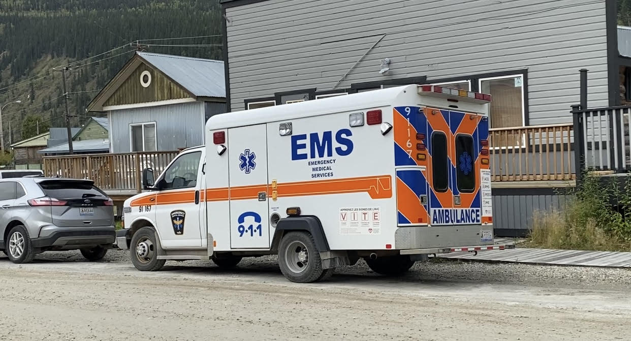 An ambulance parked in Dawson City, Yukon. Last fall, firefighters in the community  said they were having to respond to medical calls when paramedics weren't available.  (Chris MacIntyre/CBC - image credit)