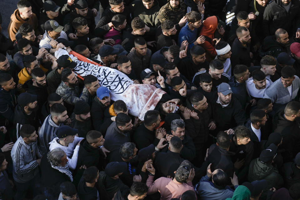 Palestinians carry the body of Hossam Selim after he was killed in clashes with Israel troops in the West Bank city of Nablus, Wednesday, Feb. 22, 2023. Israeli troops on Wednesday entered a major Palestinian city in the occupied West Bank in a rare, daytime arrest operation, triggering fighting that killed several Palestinians and wounded scores of others. (AP Photo/Majdi Mohammed)