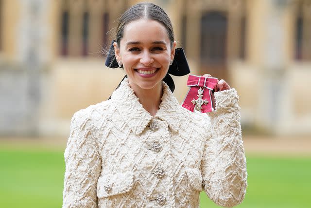 <p>Andrew Matthews - Pool/Getty Images</p> Emilia Clarke poses for a photo after being made a Member of the Order of the British Empire during an investiture ceremony at Windsor Castle, on February 21.