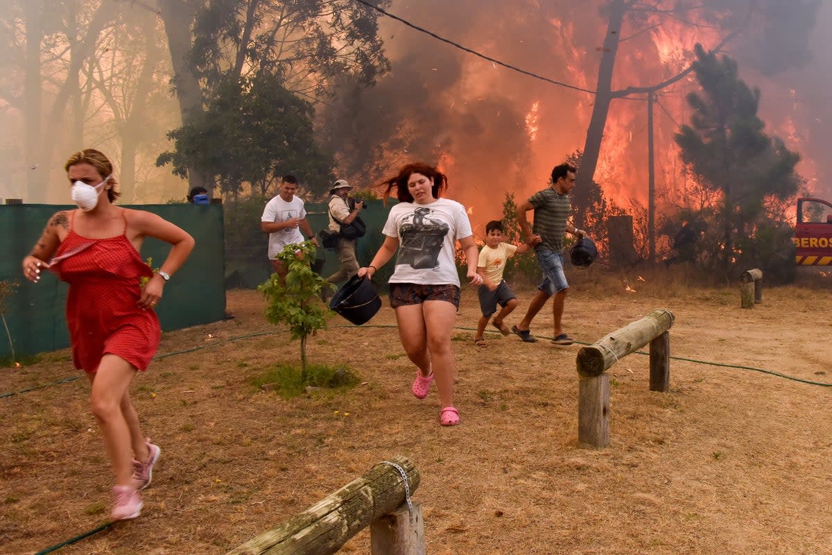 People run from flames during fire in La Floresta, Uruguay (EPA)