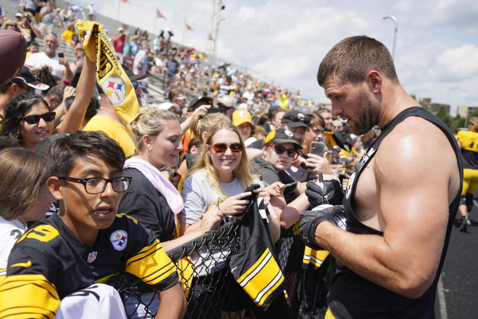 Pittsburgh Steelers linebacker T.J. Watt, right, give autographs to fans before practice at NFL football training camp in the Latrobe Memorial Stadium in Latrobe, Pa., Monday, Aug. 8, 2022. (AP Photo/Keith Srakocic)