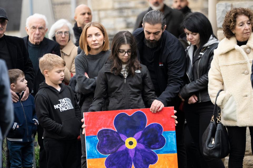 Vanessa Koulian, 12, stands with her aunt Lena Koulian and father, Arut Koulian, while she holds a painting she made to represent the Armenian culture during a prayer ceremony commemorating the Armenian genocide. In 2021, President Joe Biden became the first American president to recognize the genocide, which began in 1915; he put the dead at 1.5 million.