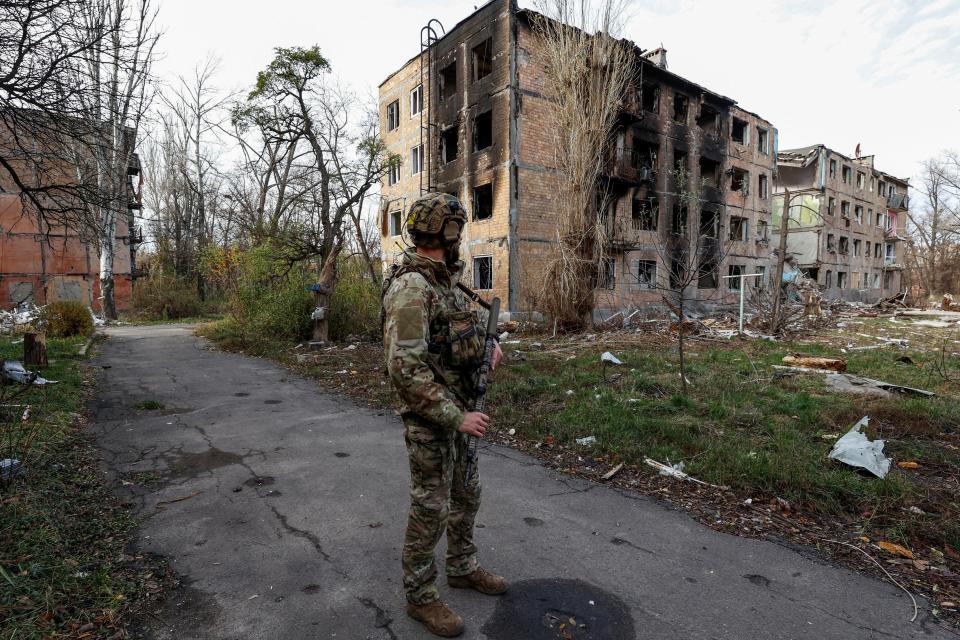 A Ukrainian serviceman stands next to residential buildings heavily damaged by permanent Russian military strikes in the front line town of Avdiivka (REUTERS)