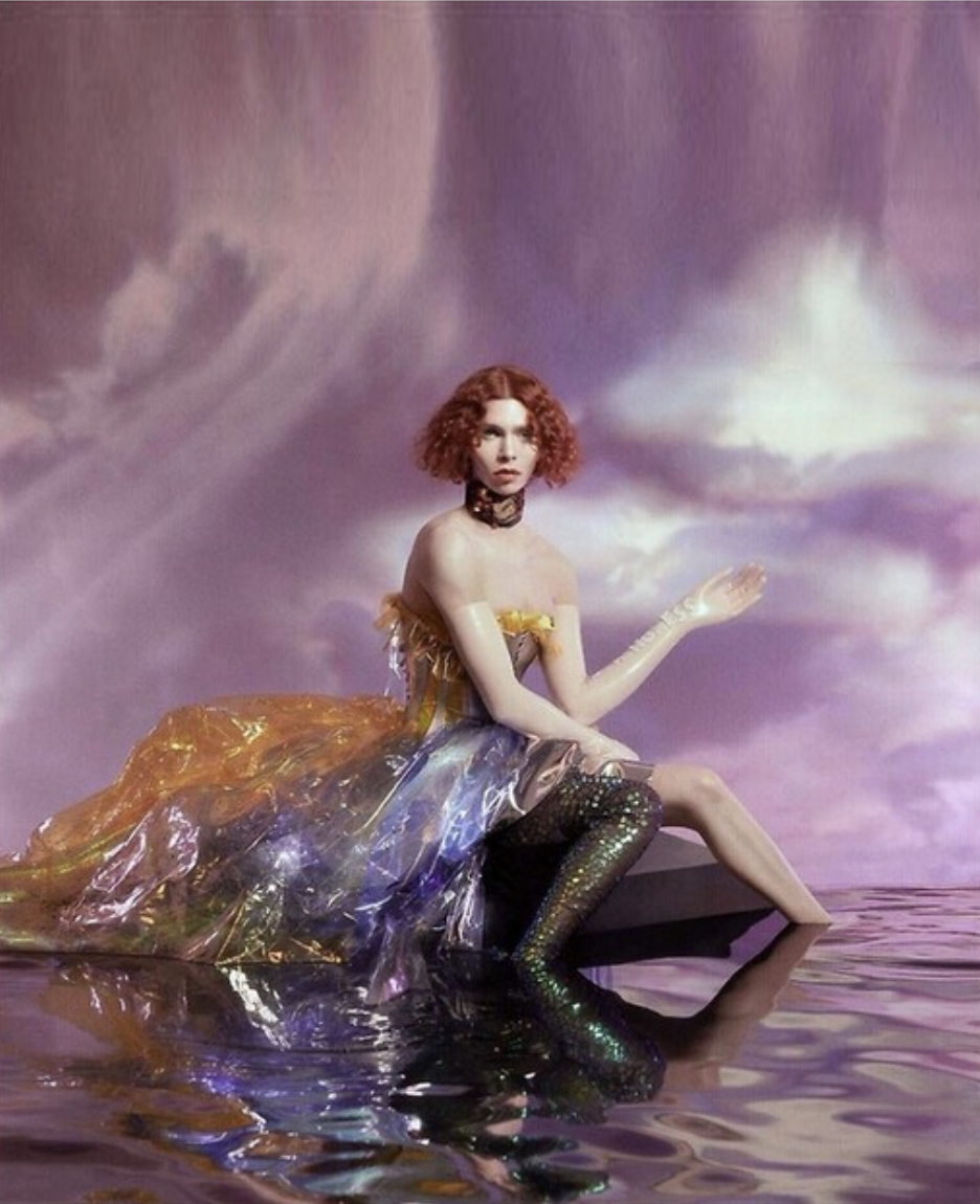 sophie sitting in a dress in water on a purple background