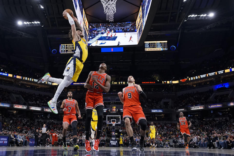 Indiana Pacers guard Duane Washington Jr. (4) dunks in front of Chicago Bulls guard Ayo Dosunmu (12) during the second half of an NBA basketball game in Indianapolis, Friday, Feb. 4, 2022. The Bulls won 122-115. (AP Photo/AJ Mast)