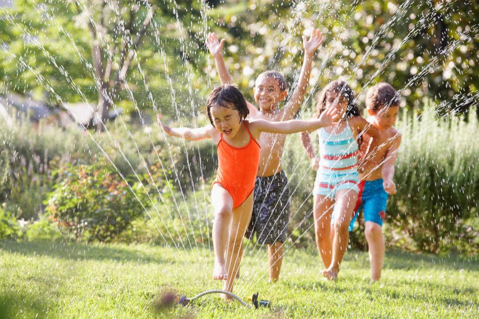 Splash out for these cheap sprinkler water toy accessories for the kiddos this summer. (Ariel Skelley via Getty Images)