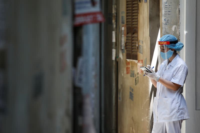 A healthcare worker is seen at a lane near the house of a coronavirus disease (COVID-19) patient while investigating infection links in Hanoi