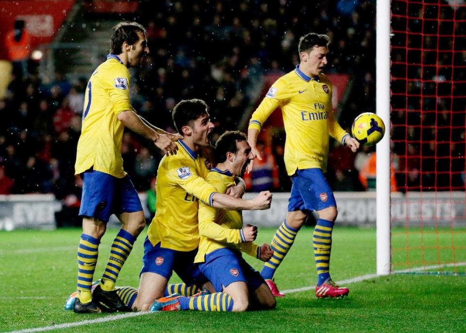 Arsenal's Santi Cazorla, third right, celebrates his goal with, from left, Mathieu Flamini, Olivier Giroud and Mesut Ozil during the English Premier League soccer match between Southampton and Arsenal at St Mary's stadium in Southampton, Tuesday, Jan. 28, 2014. (AP Photo/Matt Dunham)