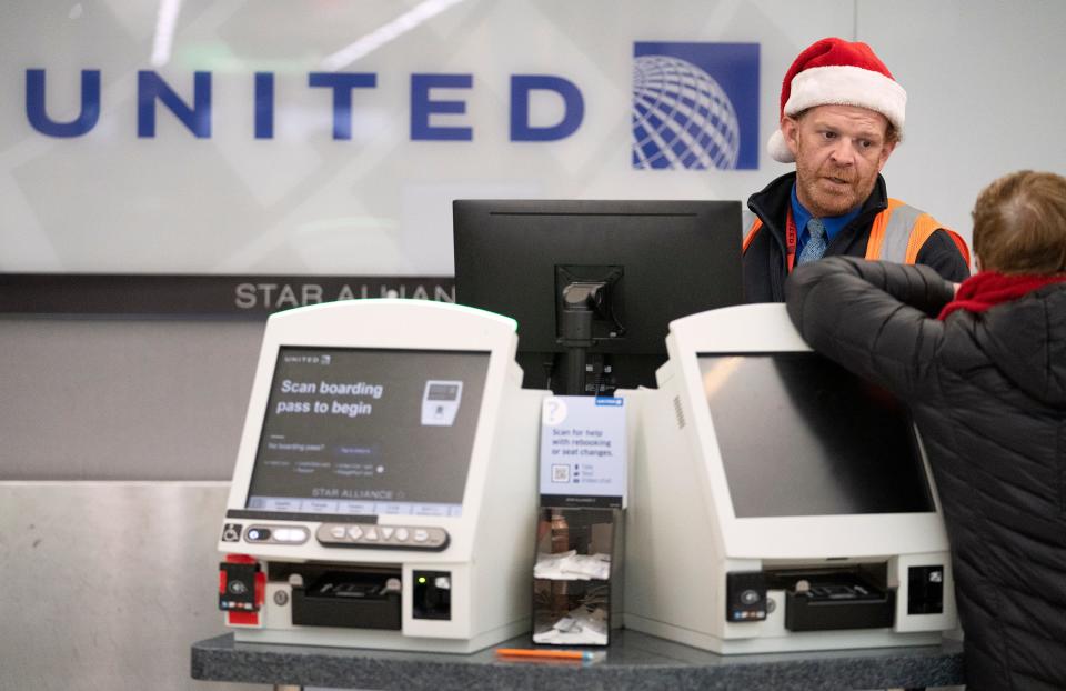 United agent Doug Provost works with a passenger whose flight to Chicago was delayed Thursday at John Glenn Columbus International Airport.