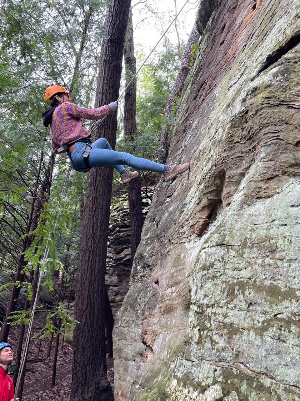 A guide at the bottom of the climb spots for a guest at High Rock Adventures.