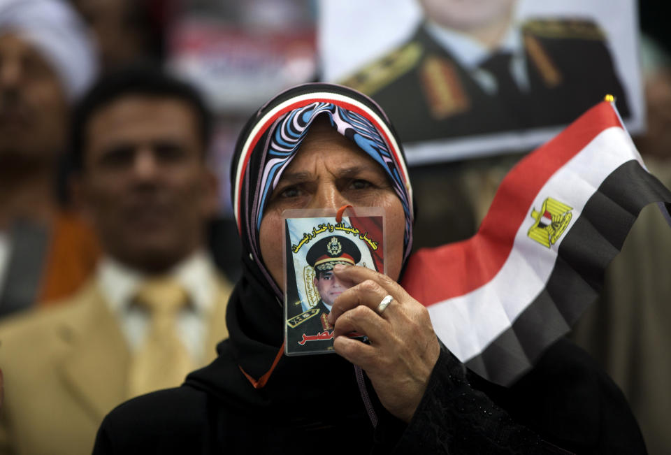 An Egyptian woman kisses a picture of Egypt's Defense Minister, Gen. Abdel-Fattah el-Sissi, during a rally in support of el-Sissi, in Cairo, Egypt, Tuesday, Jan. 21, 2014. Supporters of the powerful army chief and defense minister urged Egyptians on Tuesday to turn the third anniversary to 2011 uprising that toppled longtime autocratic president Hosni Mubarak, to a show of gratitude to the general for ousting Islamist president, calling on him to contest elections. (AP Photo/Khalil Hamra)