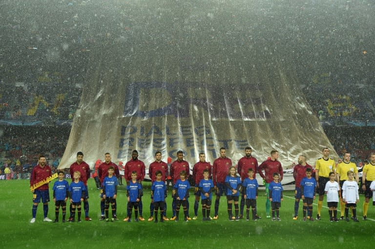 Barcelona team line up in the rain before the UEFA Champions League group D football match against Olympiacos at the Camp Nou stadium in Barcelona on Ocotber 18, 2017
