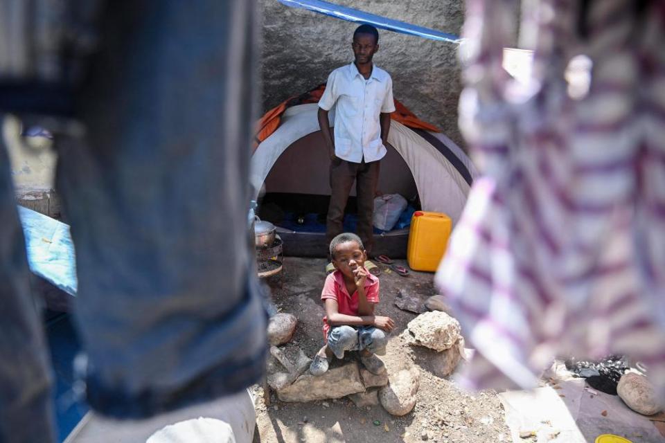Tervile Eliuse, a school principal and church pastor, with his son at a makeshift refugee camp set up by people escaping gang activity in Port-au-Prince.