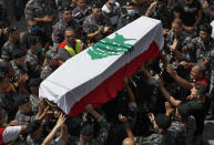 Firefighters carry the coffin of their comrade Rami Kaaki, one of ten firefighters who were killed during the last week's explosion that hit the seaport of Beirut, as friends and relatives applaud, during his funeral at the firefighter headquarters in Beirut, Lebanon, Tuesday, Aug. 11, 2020. (AP Photo/Hussein Malla)