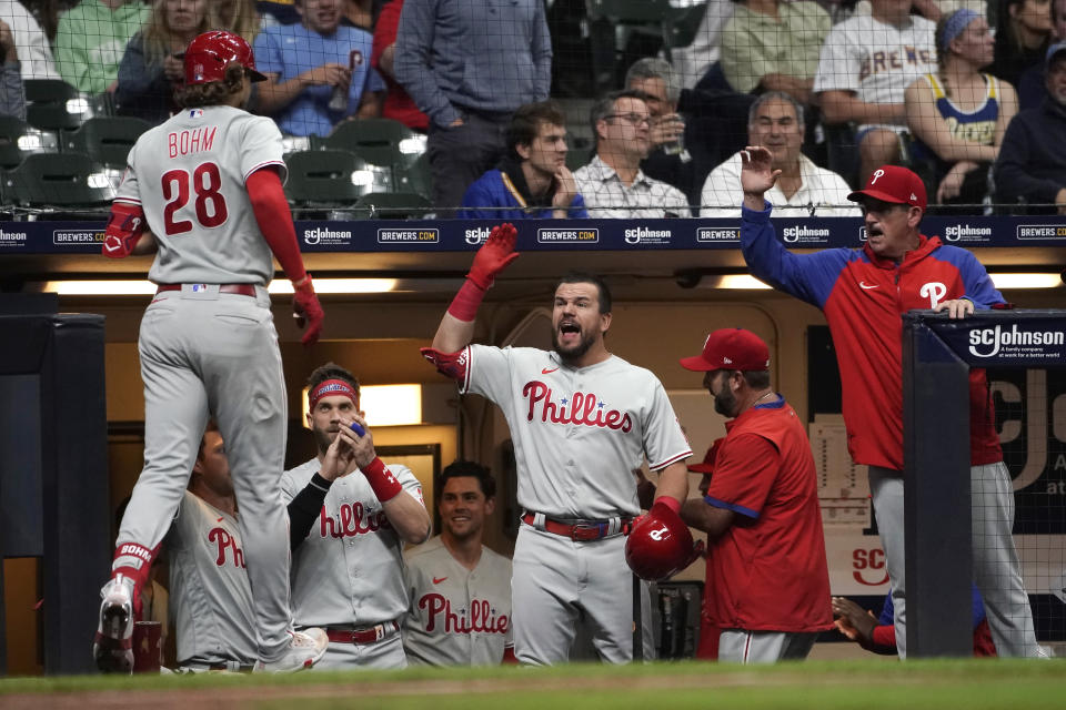 Philadelphia Phillies' Alec Bohm (28) is congratulated at the dugout by Kyle Schwarber after hitting a game-tying home run during the ninth inning of the team's baseball game against the Milwaukee Brewers on Tuesday, June 7, 2022, in Milwaukee. (AP Photo/Aaron Gash)