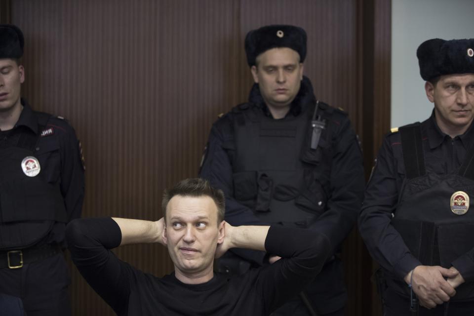 Russian opposition leader Alexei Navalny, foreground left, waits to hear a sentence in court in Moscow, Russia, Thursday, March 30, 2017. Many Western countries have condemned the arrests and called for the release of those sentenced to jail, including opposition leader Alexei Navalny, Putin's most prominent foe. (AP Photo/Pavel Golovkin)