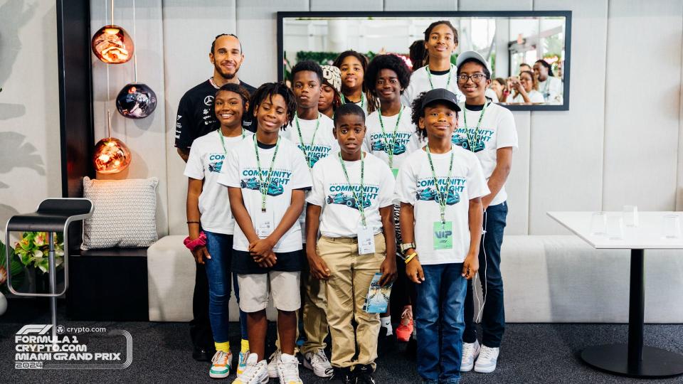 Lewis Hamilton poses with visiting children before the Miami Grand Prix.