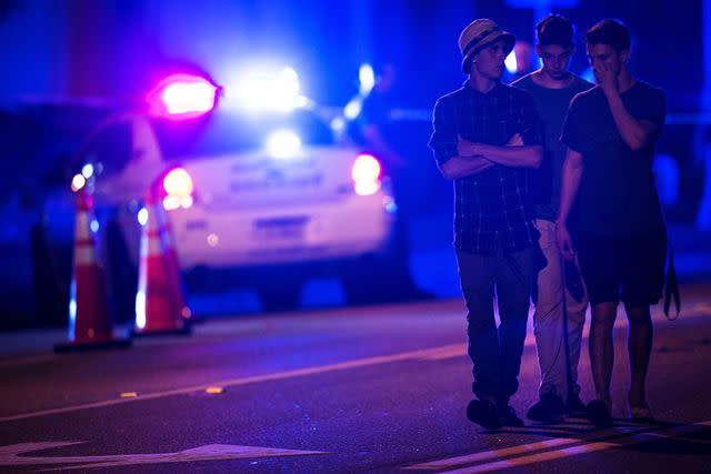 <p>Brendan Smialowski/AFP/Getty</p> People walk by a police roadblock near the Pulse nightclub on June 12, 2016, in Orlando, Florida.