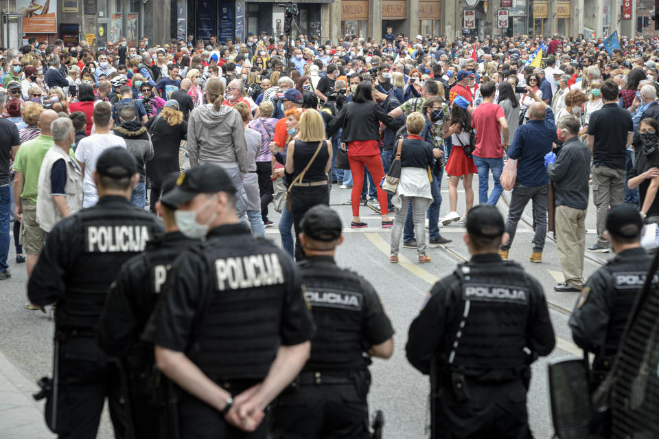 People attend an anti-Nazi protest outside the Sacred Heart Cathedral during a mass commemorating members of the pro-Nazi Croatian WWII Ustasha regime, responsible for sending tens of thousands of Serbs, Gypsies and Jews to their death in concentration camps, who were killed at the end of WWII by Yugoslav communist troops, in Sarajevo, Bosnia, Saturday, May 16, 2020. Bosnian Catholic clerics along with Croatian state representatives and members of the Bosnian Croats community attended a religious service commemorating the massacre of Croatian pro-Nazis by victorious communists at the end of World War II. (AP Photo/Kemal Softic)