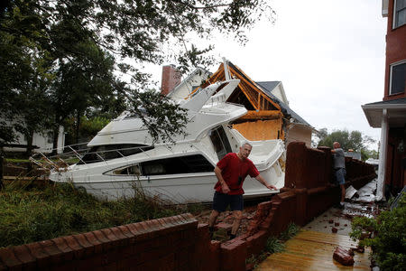 A boat is seen sitting in a backyard as people arrive to their properties to see the destruction and clean their houses after the pass of Hurricane Florence in New Bern, North Carolina, U.S., September 16, 2018. REUTERS/Eduardo Munoz