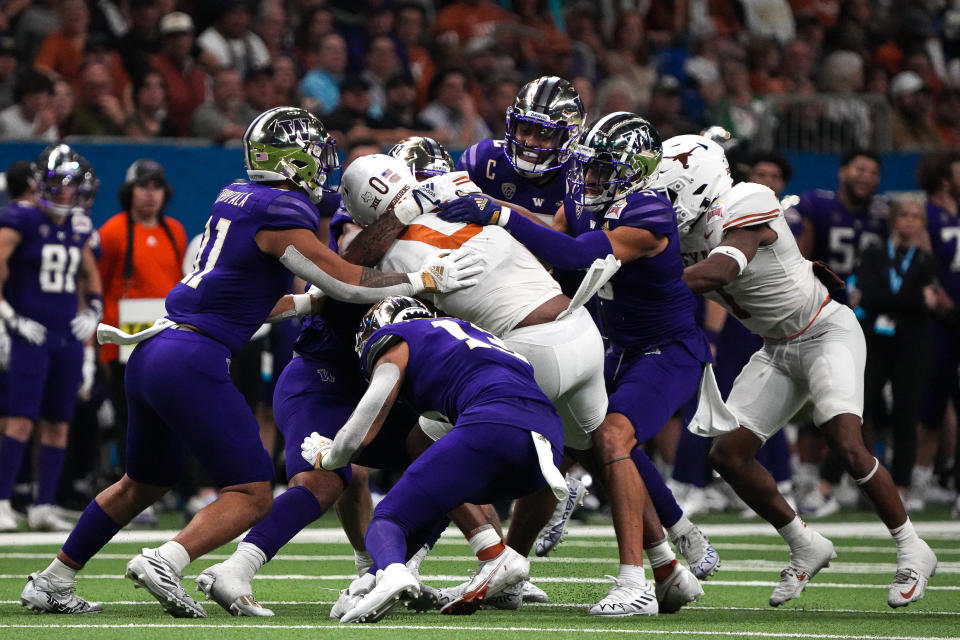 Texas tight end Ja'Tavion Sanders (0) is tackled by the Washington defense during the Alamo Bowl at the Alamodome, Thursday, Dec. 29, 2022 in San Antonio.
