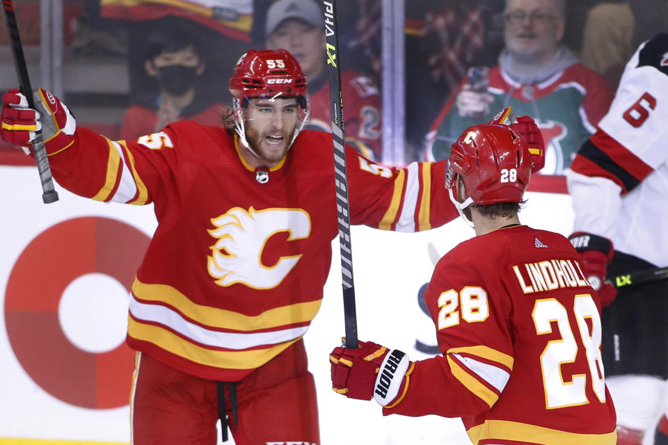 Calgary Flames' Elias Lindholm, right, celebrates his goal against the New Jersey Devils with Noah Hanifin during the second period of an NHL hockey game Saturday, Nov. 5, 2022, in Calgary, Alberta. (Larry MacDougal/The Canadian Press via AP)