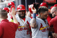 St. Louis Cardinals' Marcell Ozuna, left, and Yadier Molina, are greeted by teammates after scoring off Tommy Edman's doubles during the first inning of Game 5 of their National League Division Series baseball game against the Atlanta Braves, Wednesday, Oct. 9, 2019, in Atlanta. (AP Photo/John Bazemore)