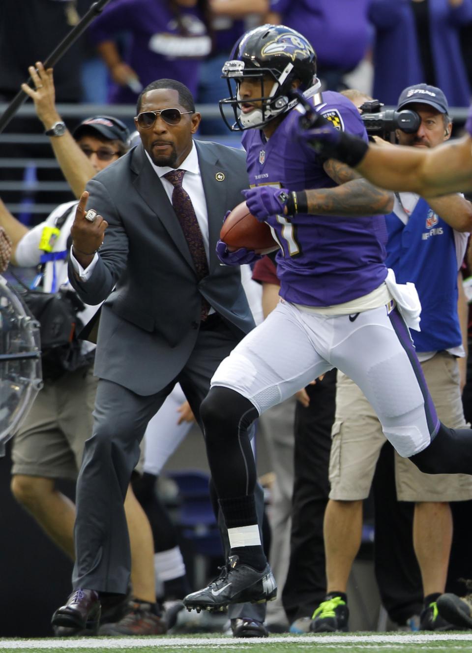 Baltimore Ravens' Tandon Doss (17) returns a punt for a touchdown, as former Ravens great Ray Lewis (L) cheers, during the second quarter of their NFL football game against the Houston Ravens in Baltimore, Maryland September 22, 2013. REUTERS/Richard Clement (UNITED STATES - Tags: SPORT FOOTBALL)