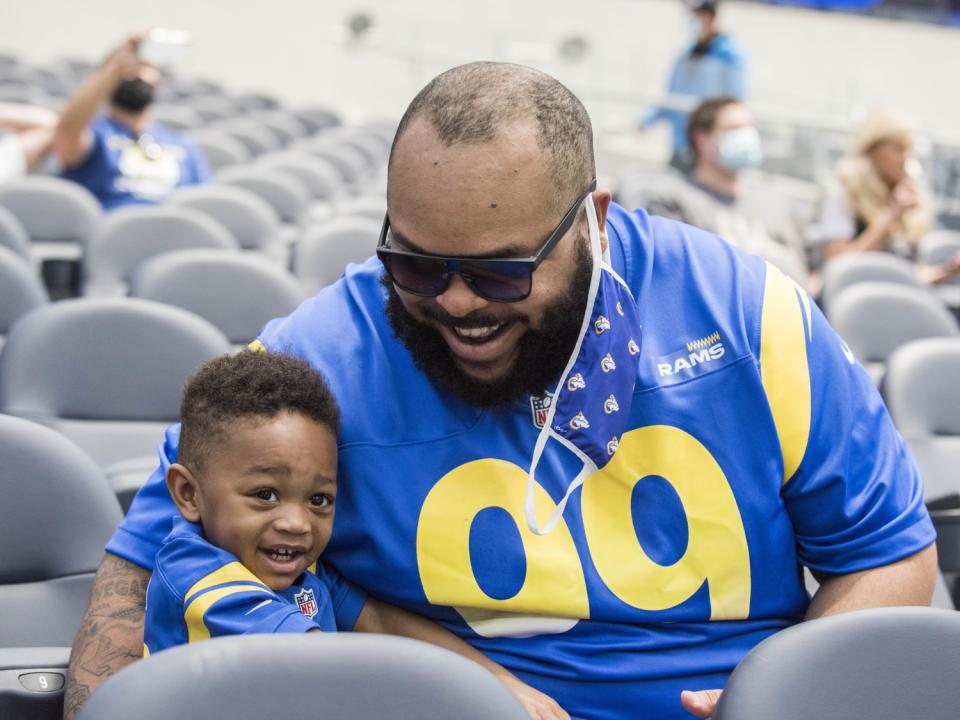 Rams season ticket holder Christian Paris, right, and son Harper Paris, tour SoFi Stadium in Inglewood on Saturday.