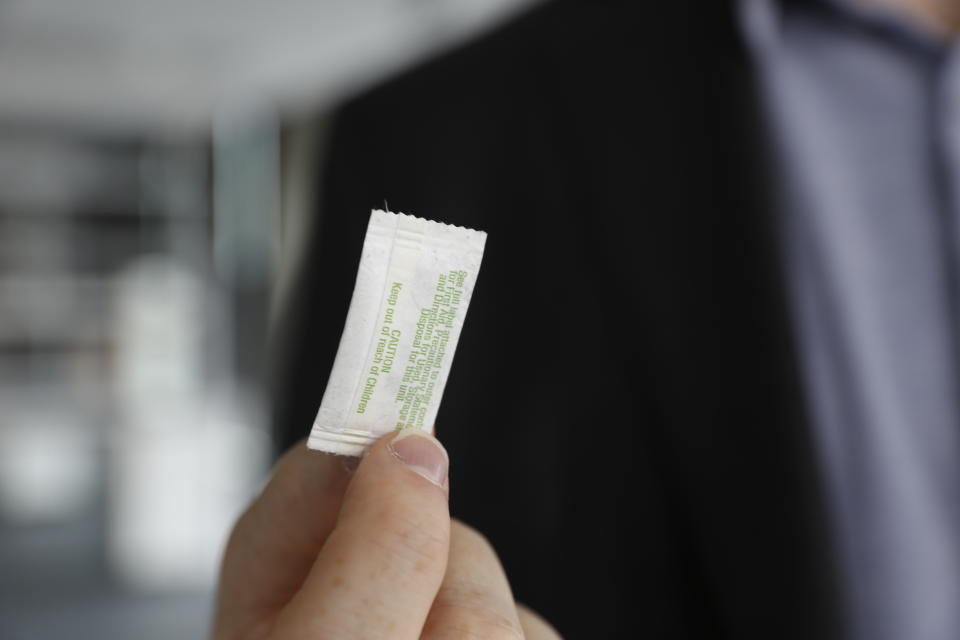 In this photo taken Monday, Oct. 24, 2022, in Chicago, Patrick Flynn, a co-founder of Hazel Technologies, holds a sachet designed to slow the ripening of process of various fruits. The ingredients of the packet use scientific concepts to inhibit the naturally occurring hormone ethylene, which causes produce to ripen. The product is used for apples, table grapes, peaches, avocados and other items. (AP Photo/Martha Irvine)