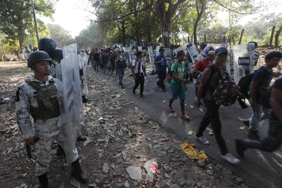 Mexican National Guards detain migrants near Tapachula, Mexico, Thursday, Jan. 23, 2020. Hundreds of Central American migrants crossed the Suchiate River into Mexico from Guatemala Thursday after a days-long standoff with security forces. (AP Photo/Marco Ugarte)