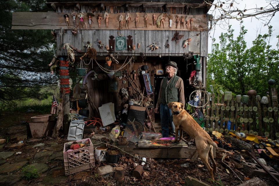 Cecil Ison stands with his dog Jabberwocky outside one of the buildings at the Home for Wayward Babydolls. April 19, 2019