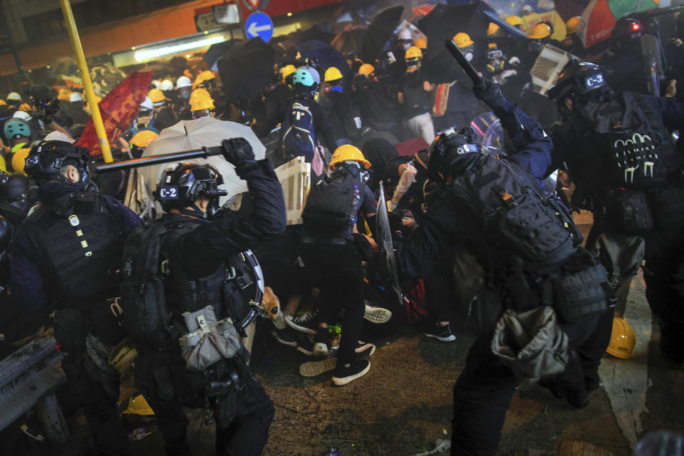 Policemen use batons charge on protesters during a protest in Hong Kong, Sunday, July 28, 2019. Police fired tear gas at protesters in Hong Kong on Sunday for the second night in a row in another escalation of weeks-long pro-democracy protests in the semi-autonomous Chinese territory. (Jeff Cheng/HK01 via AP)