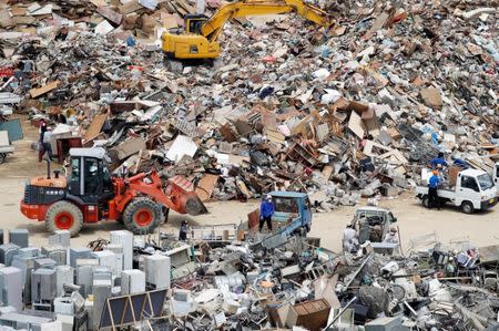 Local residents pile up household waste, caused by a flooding, at a temporary waste-collection point at Mabi Clean Center in Kurashiki, Okayama Prefecture, Japan, July 13, 2018. REUTERS/Issei Kato