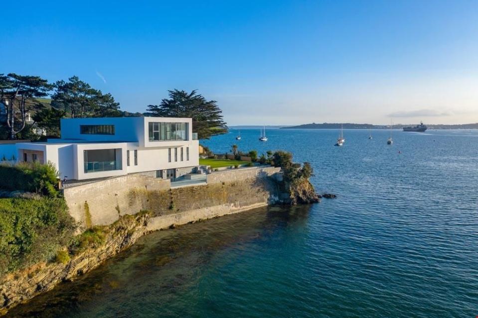 <p>This picture-perfect new-build home is nestled in a quaint waterside spot in Cornwall. On the market for £4.5 million, it boasts stunning sea views and direct access to a shingle beach. The incredible home has a contemporary architectural style, four en-suite bedrooms and a secluded sunken terrace above the beach – the ideal spot for watching sunsets.</p><p><a class="link " href="https://www.rightmove.co.uk/property-for-sale/property-65588694.html" rel="nofollow noopener" target="_blank" data-ylk="slk:TOUR NOW;elm:context_link;itc:0;sec:content-canvas">TOUR NOW</a></p>